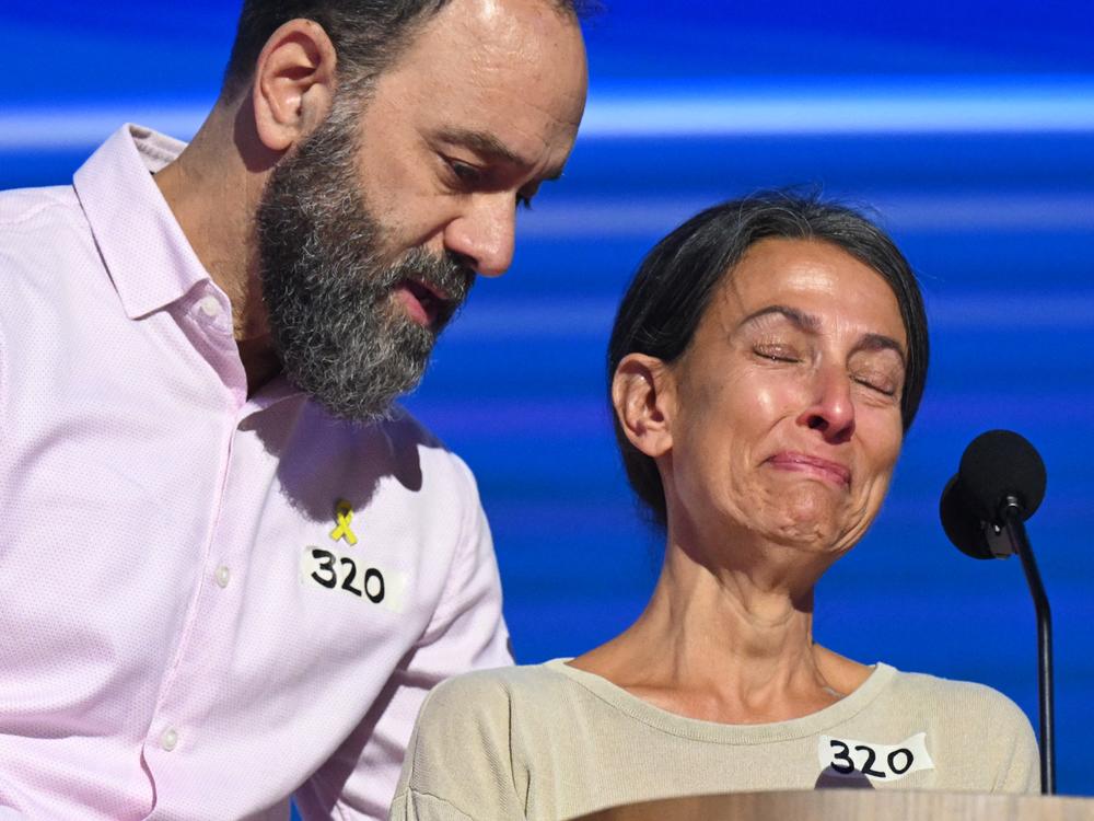 Jon Polin (L) comforts his wife Rachel Goldberg as she speaks about their son Hersh Goldberg Polin, who is being held hostage by Hamas, on the third day of the Democratic National Convention in Chicago. 