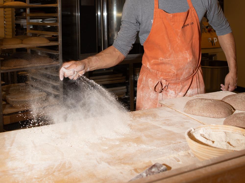 Robin Morgan of Washington State University's Bread Lab works to prepare fresh loaves of whole wheat bread. Morgan is part of a team of scientists and researchers searching for ways to make whole wheat bread resilient to a warming world — and more delicious.