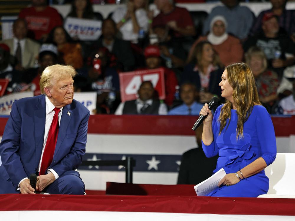 Former President Trump attends a town hall meeting moderated by Arkansas Gov. Sarah Huckabee Sanders at the Dort Financial Center in Flint, Mich., on Tues.