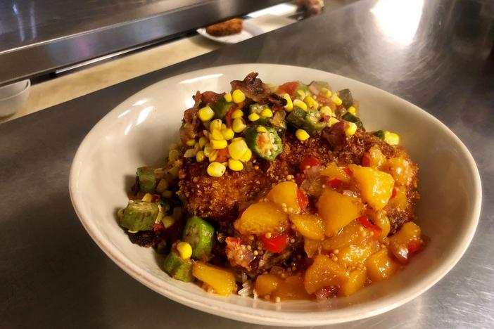 Crusted porkchop, topped with succotash and drizzled with peach murstada.