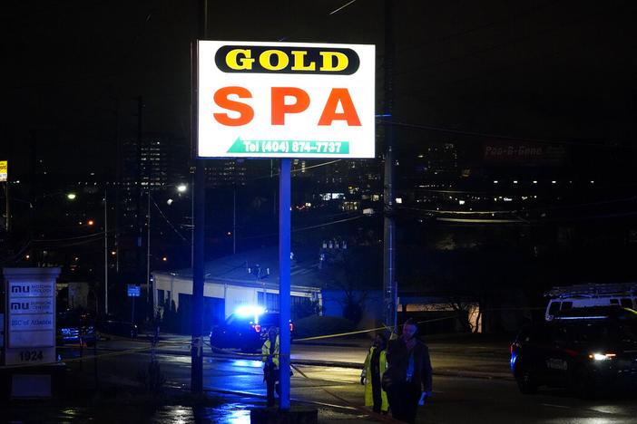 Officials talk on the phone in front of Gold Spa after a shooting on Tuesday, March 16, 2021, in Atlanta. Shootings at two massage parlors in Atlanta and one in the suburbs left multiple people dead, many of them women of Asian descent, authorities said. A 21-year-old man suspected in the shootings was taken into custody in southwest Georgia hours later after a manhunt, police said. 