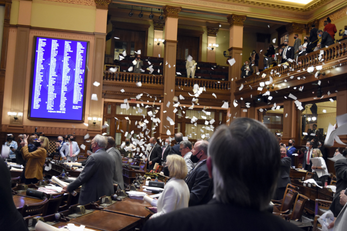 Lawmakers throw torn papers into the air at the end of the 2021 legislative session in the General Assembly just after midnight on April 1, 2021.