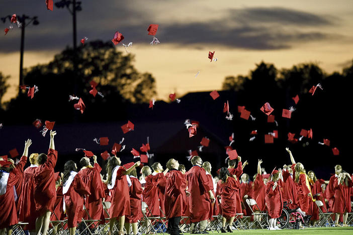 Red mortarboards fly into the evening sky at Heritage High School's commencement ceremony Friday, July 24, 2020, in Maryville Tenn. High school graduation rates dipped in at least 20 states after the first full school year disrupted by the pandemic, according to a new analysis by Chalkbeat.
