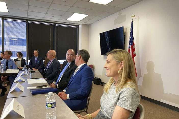 Georgia Attorney General Chris Carr speaks to Gov. Brian Kemp, second right, during an anti-gang task force meeting on Wednesday, Feb., 9, 2022, in Atlanta, as Marty Kemp, the governor's wife, looks on. Carr and Kemp are supporting moves to give Carr's office more power to prosecute gang crimes.