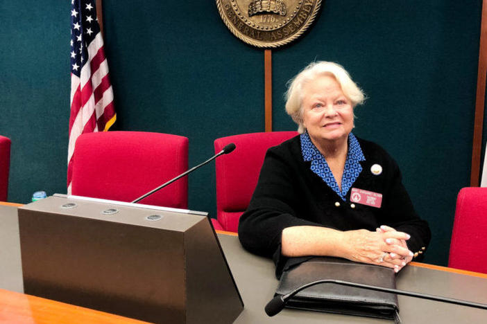 Representative Mary Margaret Oliver sits at a desk.