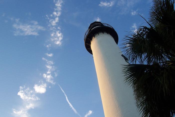 The St. Simons Island Lighthouse is shown under a blue sky.