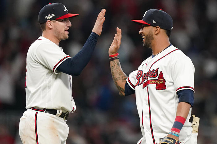 Atlanta Braves Austin Riley, left, and Atlanta Braves Eddie Rosario celebrate a win during the ninth inning in Game 2 of baseball's National League Division Series, Wednesday, Oct. 12, 2022, in Atlanta. The Atlanta Braves won 3-0.(AP Photo/Brynn Anderson)