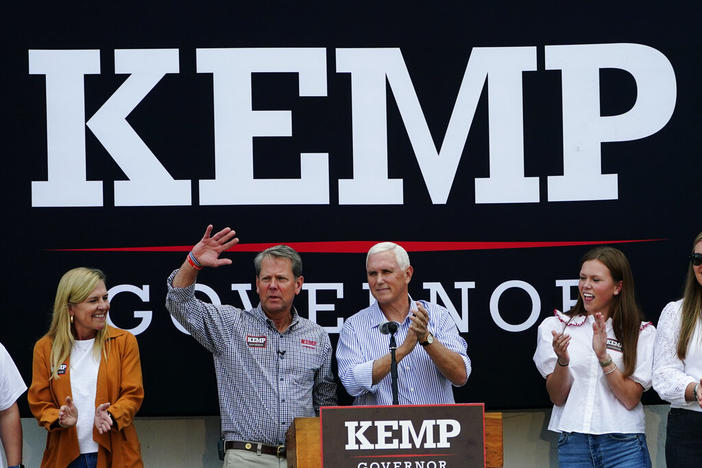 Republican Gov. Brian Kemp, second from left, and former Vice President Mike Pence acknowledge the crowd during a campaign rally for Kemp's reelection bid, Tuesday, Nov. 1, 2022 in Cumming, Ga., as First Lady Marty Kemp, left, and daughter Amy Porter Kemp look on . (AP Photo/John Bazemore)