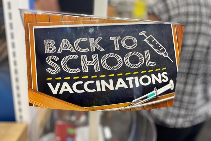 A sign saying "back to school vaccinations" in a pharmacy