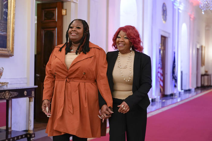 Presidential Citizens Medal honorees Shaye Moss, a former Georgia election worker, left, and her mother Ruby Freeman arrive in the East Room of the White House in Washington, Jan. 6, 2023, for a ceremony to mark the second anniversary of the Jan. 6 assault on the Capitol and to award Presidential Citizens Medals. The pressure campaign and threats against the two Georgia election workers figured prominently in this week's indictment of Donald Trump.