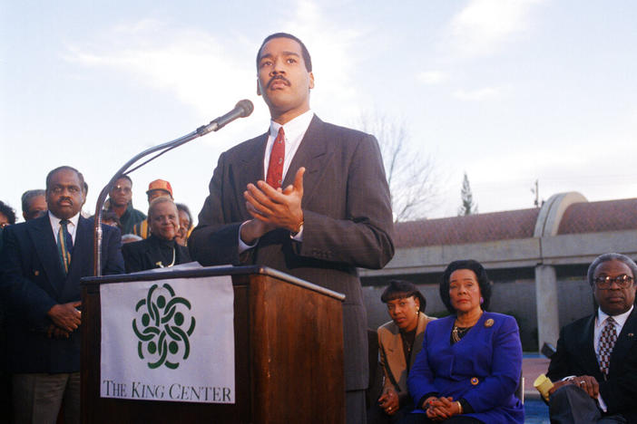 Dexter King, son of Martin Luther King Jr., speaks to the press outlining his family's plan for an interactive museum to be built at the MLK Center in Atlanta, Dec. 28, 1994. The King family has ordered all National Park Service tours of King's birthplace and tomb be stopped as the King family dispute with the government escalated on Wednesday. Coretta Scott King, right, and her daughter Bernice are seated in the background. (AP Photo/Leita Cowart)