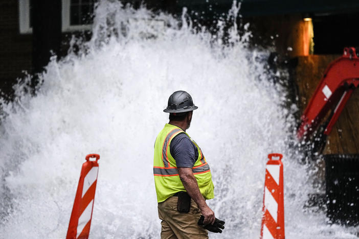 A crew member walks near a broken water transmission line, Saturday, June 1, 2024, in Atlanta. Much of Atlanta, including all of downtown, has been without water since Friday afternoon after crews began work to repair breaks on transmission lines in the downtown area. 