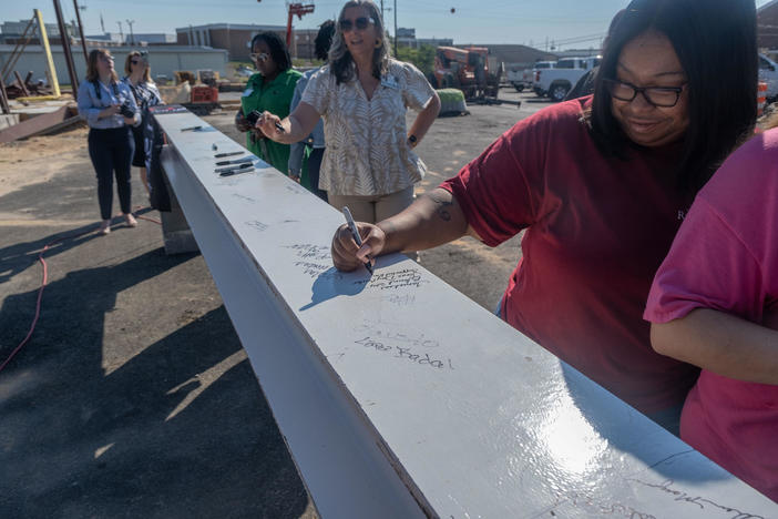People sign the final structural beam of the Crisis Stabilization Diagnostic Center before it was put into place on June 14 in Macon. The center will serve people with intellectual and developmental disabilities who need health care or are in crisis.