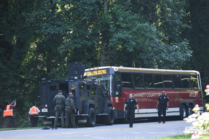 A Gwinnett County commuter bus sits in the road where it was stopped in Smoke Rise, Ga., on Tuesday, June 11, 2024. Atlanta police say the transit bus fled from officers responding to a dispute on board, leading them on a wild and lengthty chase into a neighboring county before it was stopped. (AP Photo/Ben Gray)