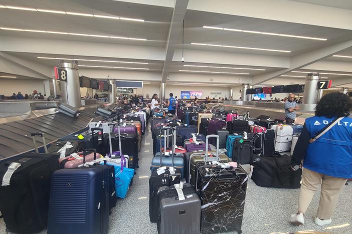 Hundreds of suitcases are lined up near baggage claim at the airport in long lines