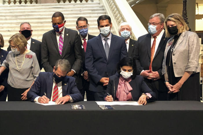 Georgia Gov. Brian Kemp, left, and Centers for Medicare and Medicaid Services Administrator Seema Verma, right, sign healthcare waivers at the state Capitol in Atlanta, Oct. 15, 2020.