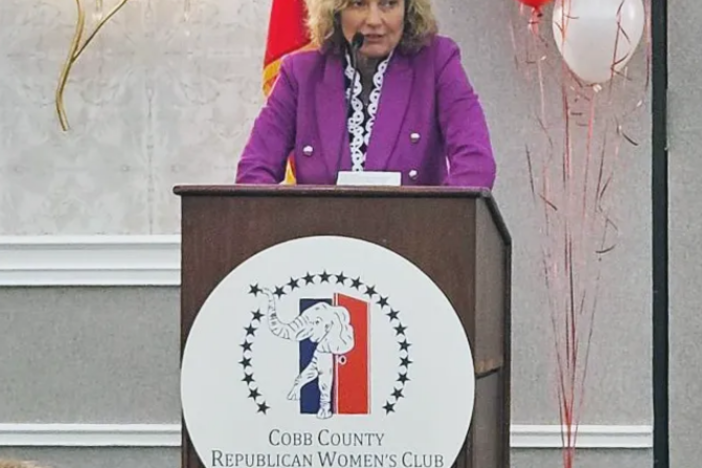 Pamela Reardon is shown speaking at a podium that has a Republican logo and says "Cobb County Republican Women's Club."