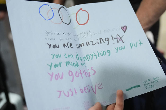 Team USA weightlifting athlete, Hampton Morris reads an encouraging note from a local high schooler as they depart from the airport for the Summer Olympic Games, on Wednesday, July 17, 2024, in Atlanta.