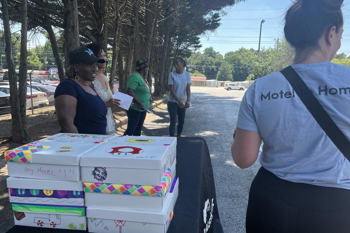 Volunteers with Frontline Housing hand out hygiene kits full of supplies at motels in South Atlanta as part of their monthly outreach services.