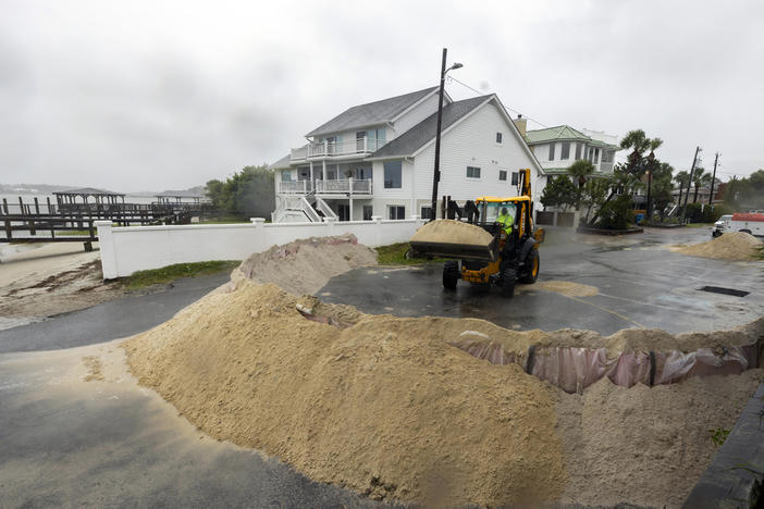 Tybee Island Department of Public Works employee Bruce Saunders uses a backhoe to pile sand as a barriers against storm surge from Tropical Storm Debby at a beach access point, Monday, Aug. 5, 2024, in Tybee Island, Ga. 