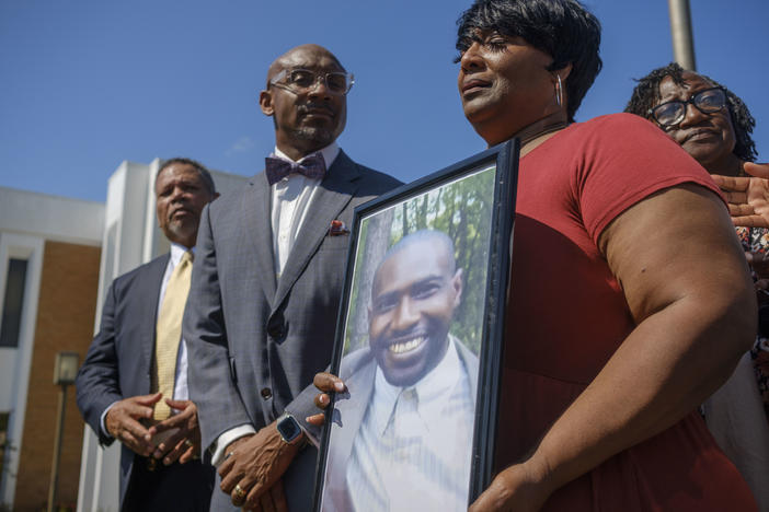 Paula Platt holds a photo of her son Stephen Fossett during a press conference in which she and attorneys for her family pressed for more details in Fossett's death during detention by the Bibb County Jail. 