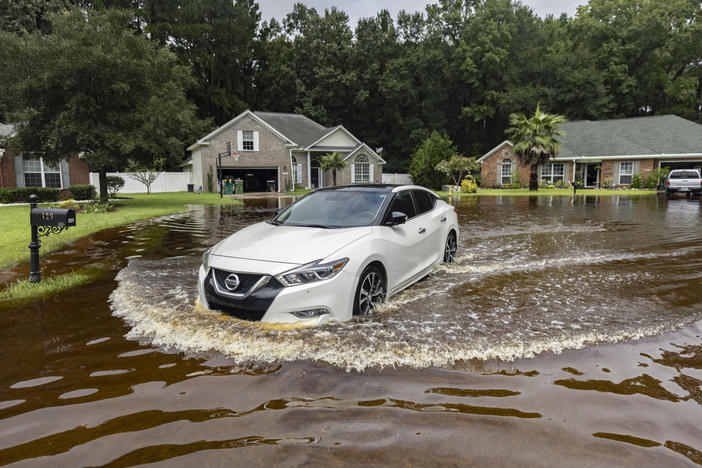 Keon Johnson leaves his house on his way to work down a street that flooded on Monday from Tropical Storm Debby and still hasn't drained, Wednesday, Aug. 7, 2024, in Pooler, Ga. 