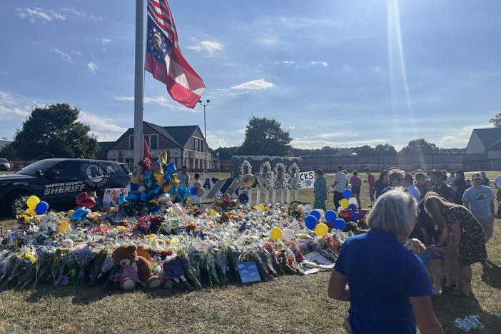 Community members and students gather around a flagpole on the Apalachee High School campus near Winder, Georgia, on Sept. 8, leaving flowers and messages to memorialize the four people killed in the Sept. 4 shooting there. 