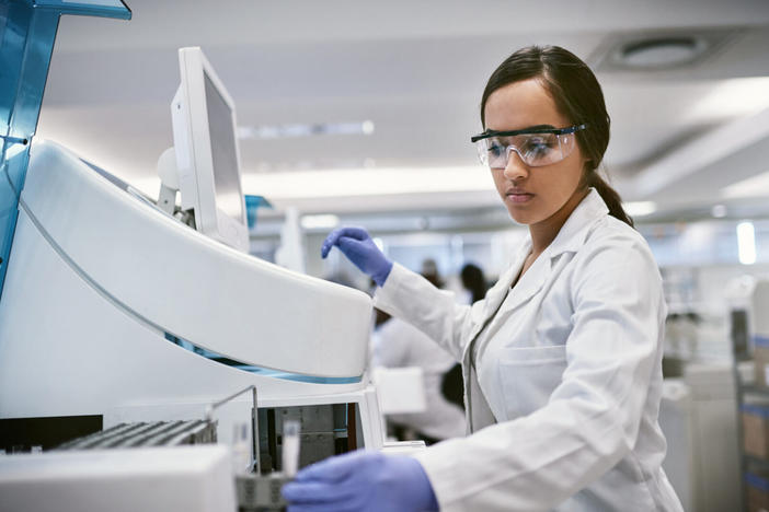 woman wearing goggles and gloves in a science lab