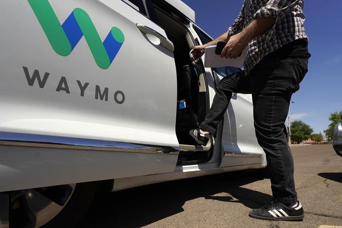 A Waymo minivan arrives to pick up passengers for an autonomous vehicle ride, Wednesday, April 7, 2021, in Mesa, Ariz.