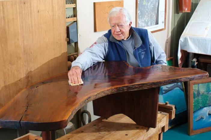 Jimmy Carter polishing furniture.