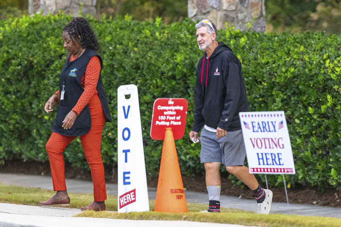 Voters are seen exiting the polling station, Thursday, Oct. 31, 2024, in Stockbridge, Ga. 