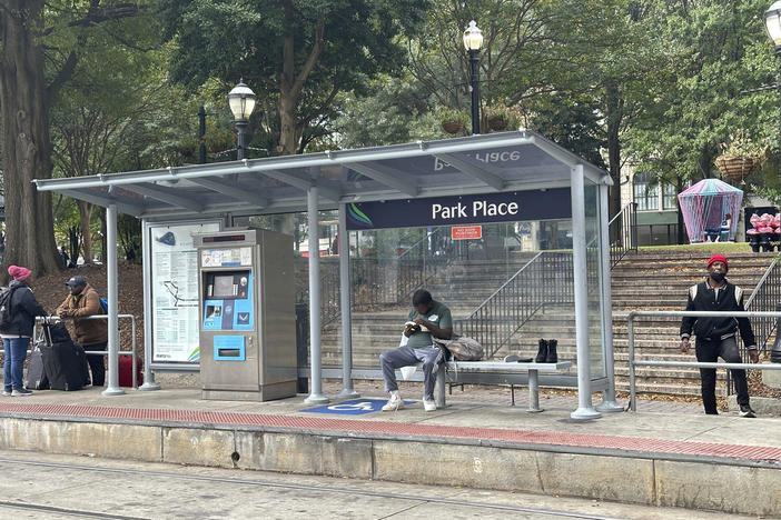 A man sits on the streetcar platform at Woodruff Park in downtown Atlanta on Wednesday, Nov. 13, 2024.