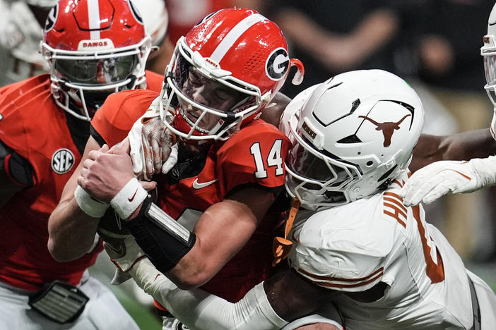 Texas linebacker Anthony Hill Jr. (0) hits Georgia quarterback Gunner Stockton (14) during the second half of the Southeastern Conference championship NCAA college football game, Saturday, Dec. 7, 2024, in Atlanta. 