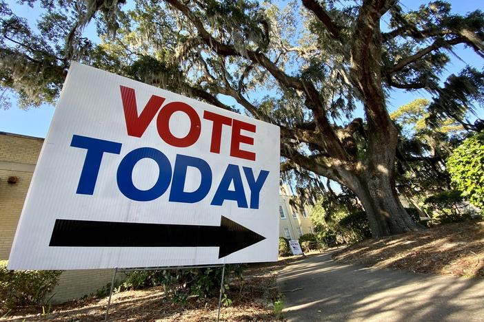 A yard sign reading "vote today" sits outside a polling place in Savannah, with a live oak tree and Spanish moss in the background.