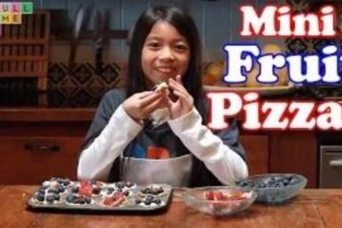 Learn how to make a dessert pizza using cookies and fruit with cream cheese frosting.