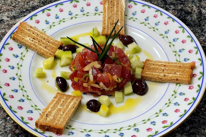 Pépin serves his tuna tartare with onions, scallions and a garnish of bread and cucumbers.