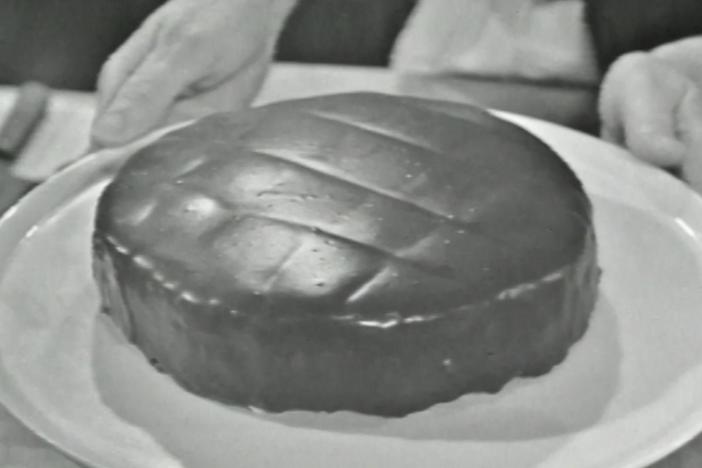 Julia Child prepares a French dessert cake with butter cream and glazed with chocolate.