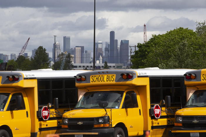 School buses sit idle in a Seattle bus yard. On July 2, Seattle Public Schools announced it is planning to resume some in-person learning in the new school year.