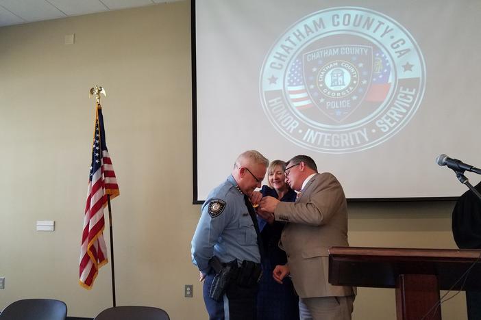Chatham County Police Chief Jeff Hadley gets his new badge from County Manager Lee Smith.