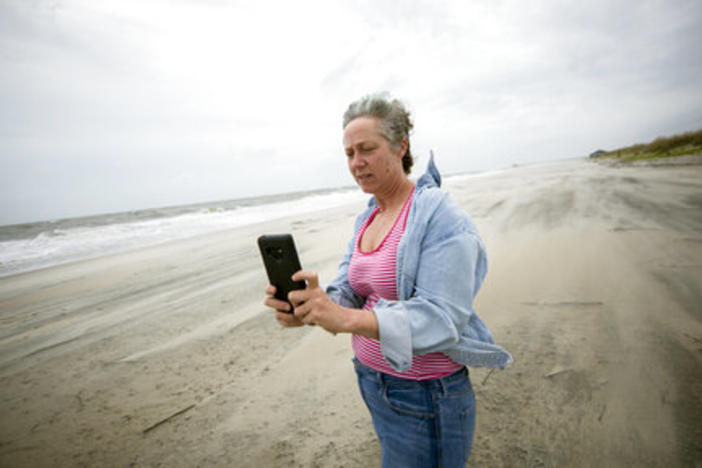 Crystal Travaille takes a cell phone photo of the wind and seas on the beach as Hurricane Dorian makes its way up the east coast, Wednesday, Sept. 4, 2019, in Tybee Island.