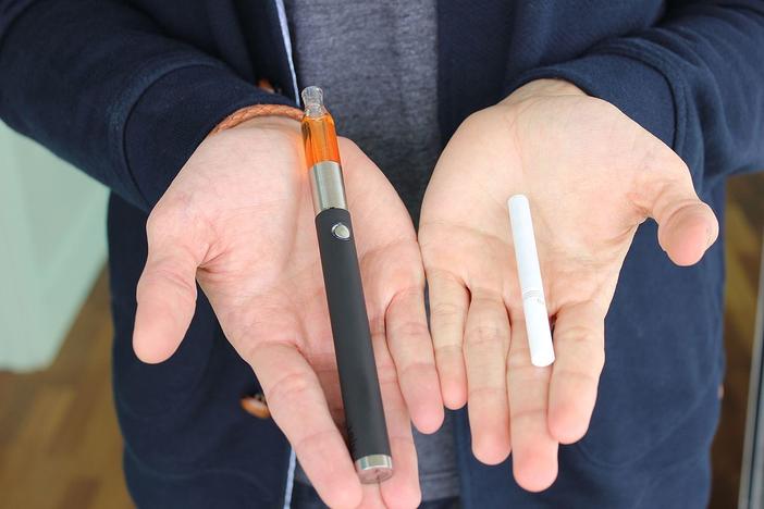 An e-cig next to a traditional cigarette. 