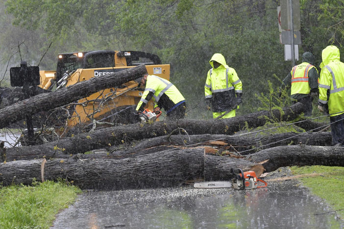 Crew members clean up fallen trees near Avia Riverside Apartments in Roswell, Ga., on April 5, 2017 as dangerous storms battered the Deep South.
