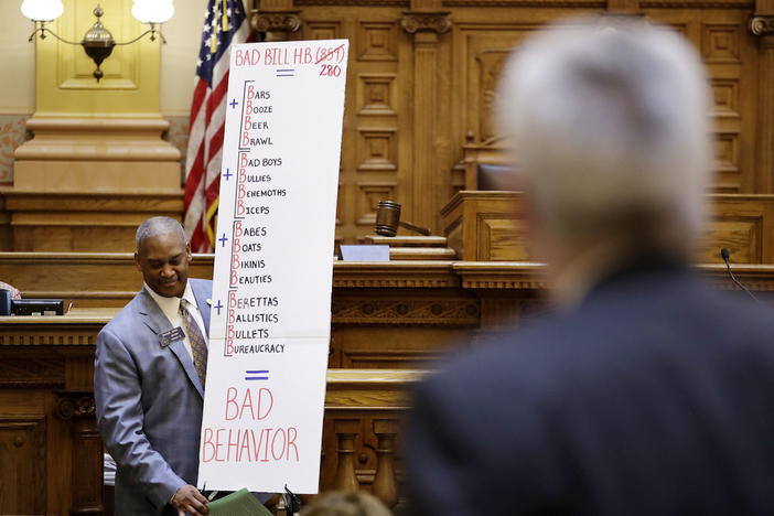 Georgia Sen. Emanuel Jones, D - Decatur, carries a poster board after speaking against a bill allowing concealed handguns on public college campuses as legislators debate the measure at the Capitol in Atlanta, Tuesday, March 28, 2017. 