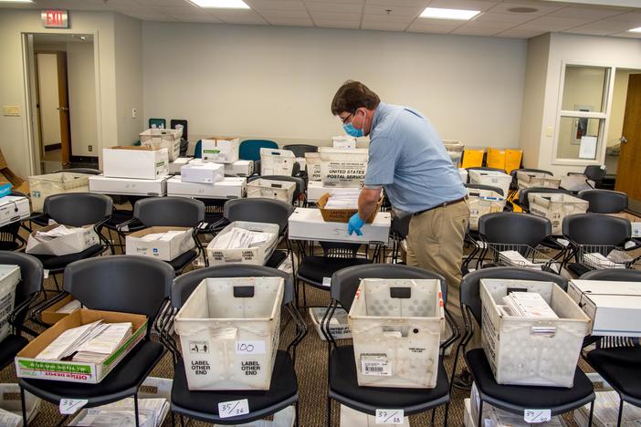 Election official Jim Fortner places a crate of sorted absentee ballots with others from the same ward at the Madison, Wis., City-County Building on Aug. 5, 2020. Delays and failure to deliver absentee ballots in Wisconsin and other key swing states have sparked concerns about how well the November presidential election will be managed during the pandemic.