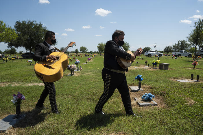 Hector Guerra, right and Juan Carlos Sanchez, from El Mariachi Continental, make their way to a funeral service in Donna, Texas on Aug. 21.