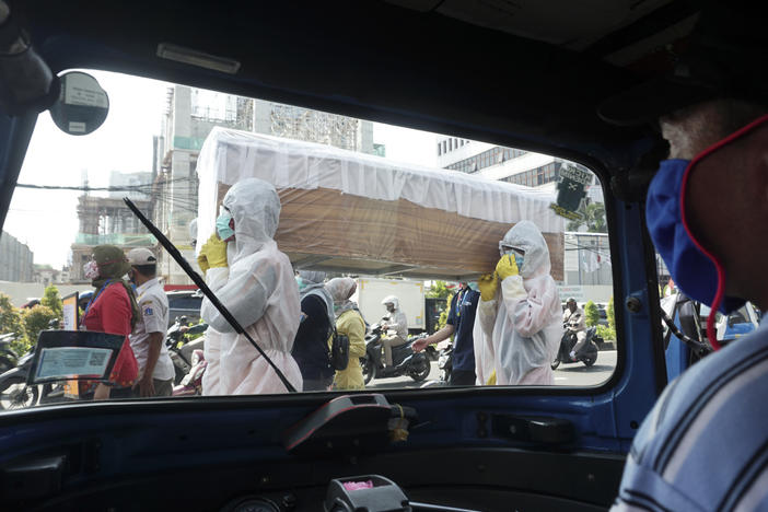 Officials from the Cilandak Subdistrict Office and Police Department carry a coffin in the streets of Jakarta, Indonesia, as part of a campaign to scare people into following pandemic guidelines.