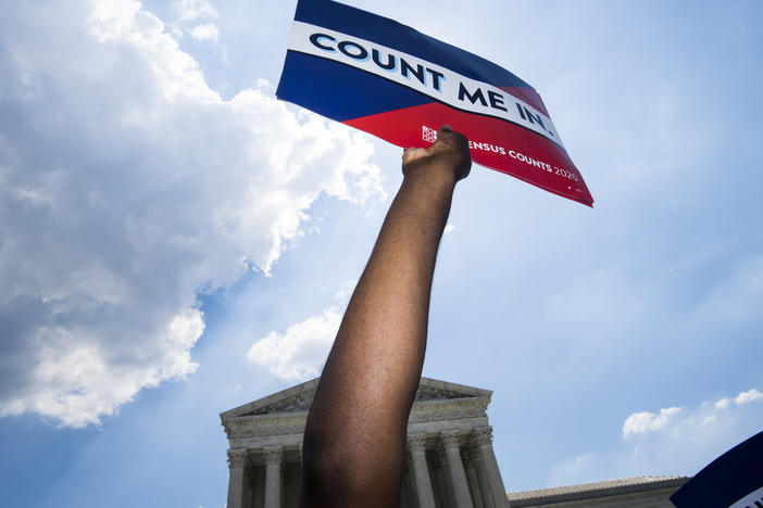 Protesters hold signs about the 2020 census at a rally in front of the Supreme Court in 2019.
