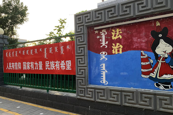 A sign (left) outside a Mongolian-language school in Hohhot, Inner Mongolia, reads: "When the people have conviction, the state has strength and the ethnic minorities have hope." The sign at right says: "Rule of law."