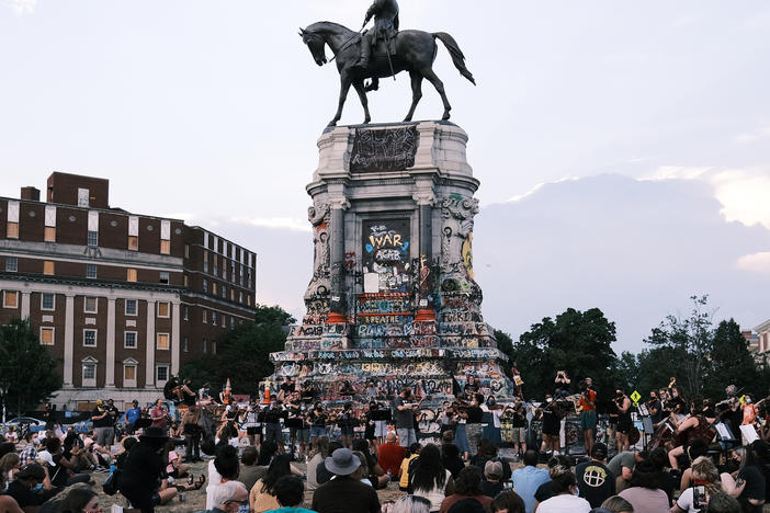 Hundreds of people gather at the Robert E. Lee monument in Richmond, Va., in July. The Mellon Foundation says it will spend $250 million over five years to re-imagine commemorative spaces in the U.S.