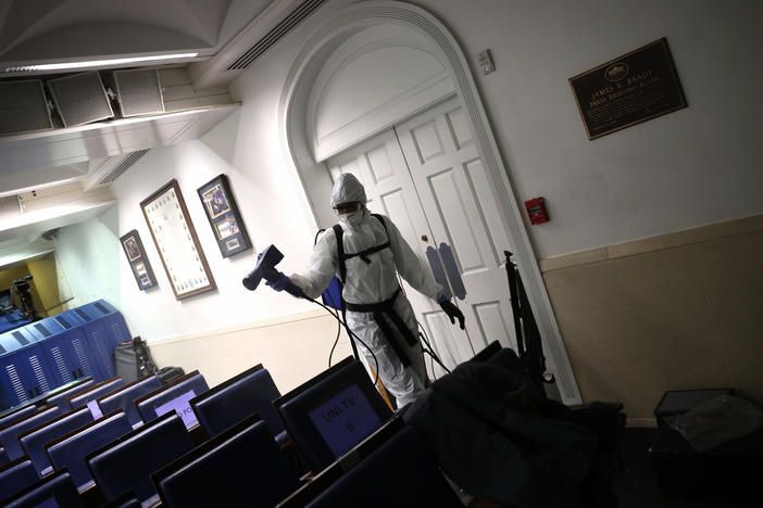 A member of the White House cleaning staff sanitizes the James S. Brady Press Briefing Room on October 5.